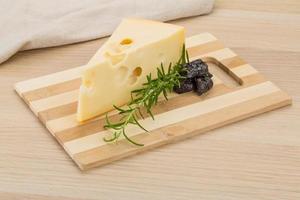 Fromage maasdam sur planche de bois et fond de bois photo