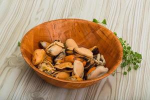 moules dans un bol sur fond de bois photo