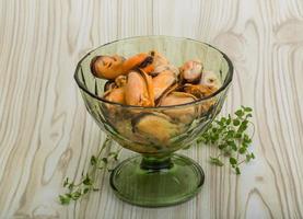 moules dans un bol sur fond de bois photo