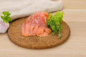 tranches de saumon sur planche de bois et fond en bois photo
