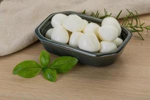 Fromage mozzarella dans un bol sur fond de bois photo