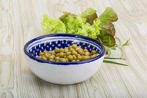 pois marinés dans un bol sur fond de bois photo