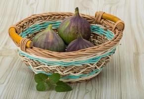 figues dans un panier sur fond de bois photo