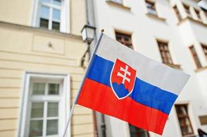 drapeau de la slovaquie en main contre la rue de bratislava. photo