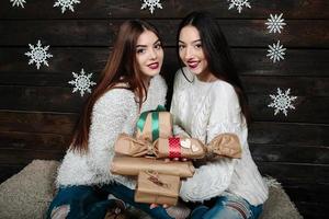 deux belles filles offrent des cadeaux à la caméra photo