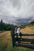 une jeune femme caucasienne attrayante assise sur une clôture photo