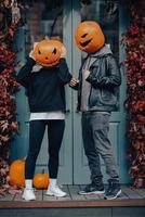 couple avec des têtes de citrouille posant sur camu à l'immeuble photo