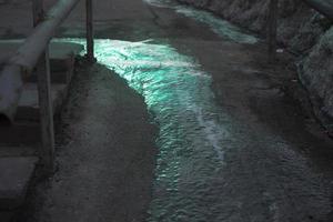 eau gelée sur l'asphalte. glace sur piste. endroit glissant à l'extérieur. photo