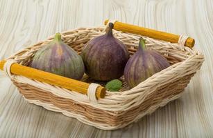 figues dans un panier sur fond de bois photo