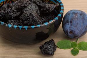 prunes séchées dans un bol sur fond de bois photo