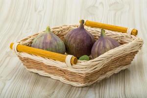 figues dans un panier sur fond de bois photo