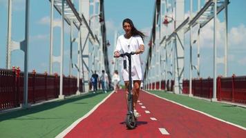 belle jeune femme et un scooter électrique, transport écologique photo