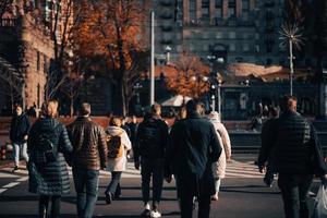 beaucoup de gens traversent la rue aux feux de circulation. photo