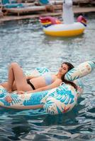 femme sur flamant gonflable flottant dans la piscine. photo