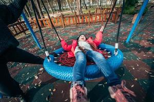 fille enfant heureuse sur la balançoire. petit enfant jouant dans le pack d'automne. photo