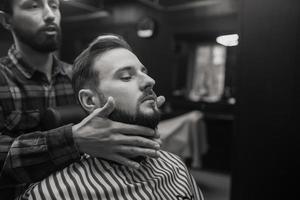 soin du visage appliquant une lotion après rasage dans un salon de coiffure. photo