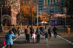 beaucoup de gens traversent la rue aux feux de circulation. photo