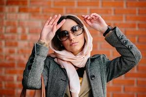 fille posant sur un fond de mur de briques rouges photo