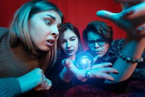 groupe de personnes et femme diseuse de bonne aventure avec boule de cristal photo