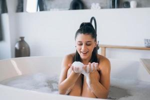 jeune femme aime la mousse en prenant un bain photo