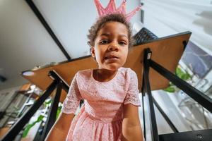 petite fille assise sur le sol grimaçant à la caméra photo