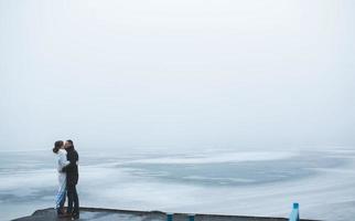 beau couple sur le quai dans le brouillard d'hiver. photo