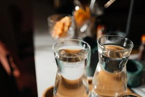 quatre tasses en verre sur le comptoir du bar avec accessoires de service. photo