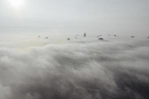 vue aérienne de la ville dans le brouillard. gratte-ciel au-dessus du brouillard photo