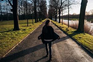 portrait d'une jeune fille brune s'amusant dans un parc sous les rayons du soleil éclatant. photo