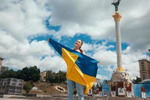 jeune femme avec le drapeau national de l'ukraine dans la rue photo