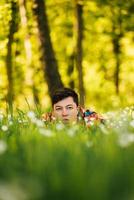 jeune homme se cachant dans l'herbe verte photo