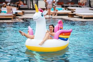 femme sur matelas gonflable licorne flotteur dans la piscine. photo