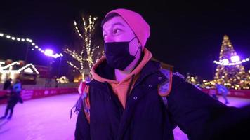 les gens aiment faire du patin à glace dans la rue autour de l'arbre de noël dans la patinoire. photo