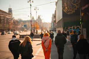 beaucoup de gens traversent la rue aux feux de circulation. photo