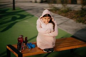 jeune sportive assise sur le banc du parc. photo