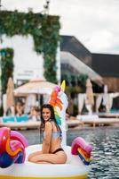 femme sur matelas gonflable licorne flotteur dans la piscine. photo