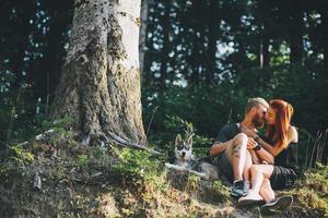 beau couple assis dans une forêt près de l'arbre photo