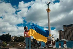 jeune femme avec le drapeau national de l'ukraine dans la rue photo