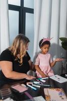 mère et enfant fille dessine de manière créative à la table photo