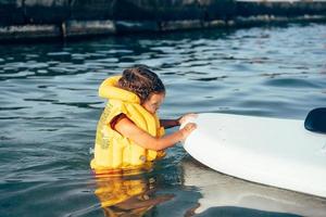 petite fille dans un gilet de sauvetage se baigner dans la mer. photo