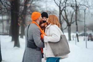 papa maman et bébé dans le parc en hiver photo
