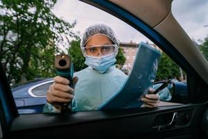 femme médecin utilise un pistolet thermomètre infrarouge pour vérifier la température corporelle photo