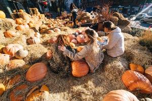 les jeunes filles sont allongées sur des meules de foin parmi les citrouilles. photo