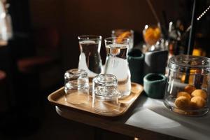 quatre tasses en verre sur le comptoir du bar avec accessoires de service. photo