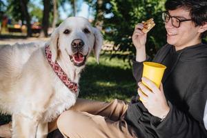 l'homme nourrit son chien des collations pour l'obéissance dans le parc photo