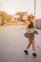 jeune fille avec une planche à roulettes sur un parking. photo