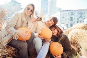 les filles tiennent des citrouilles dans les mains sur le fond de la rue. photo