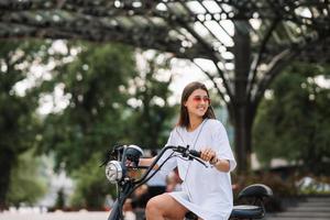 belle jeune femme et un scooter électrique, transport écologique photo