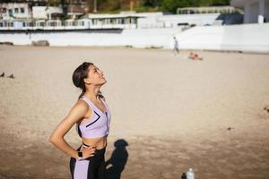 belle femme sur une plage publique après une formation avec un look sportif photo