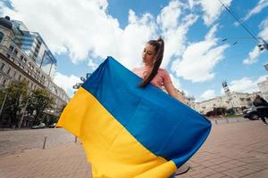 jeune femme avec le drapeau national de l'ukraine dans la rue photo